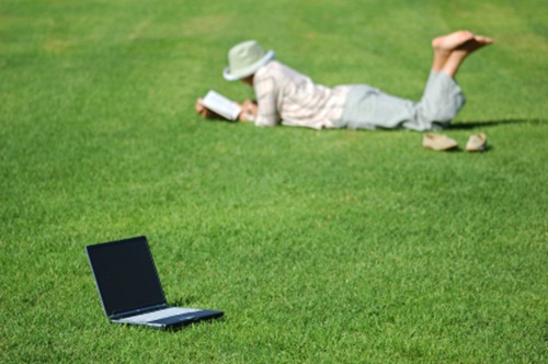 woman-reading-relax-in-grass-no-work-weekend-vacation.jpg